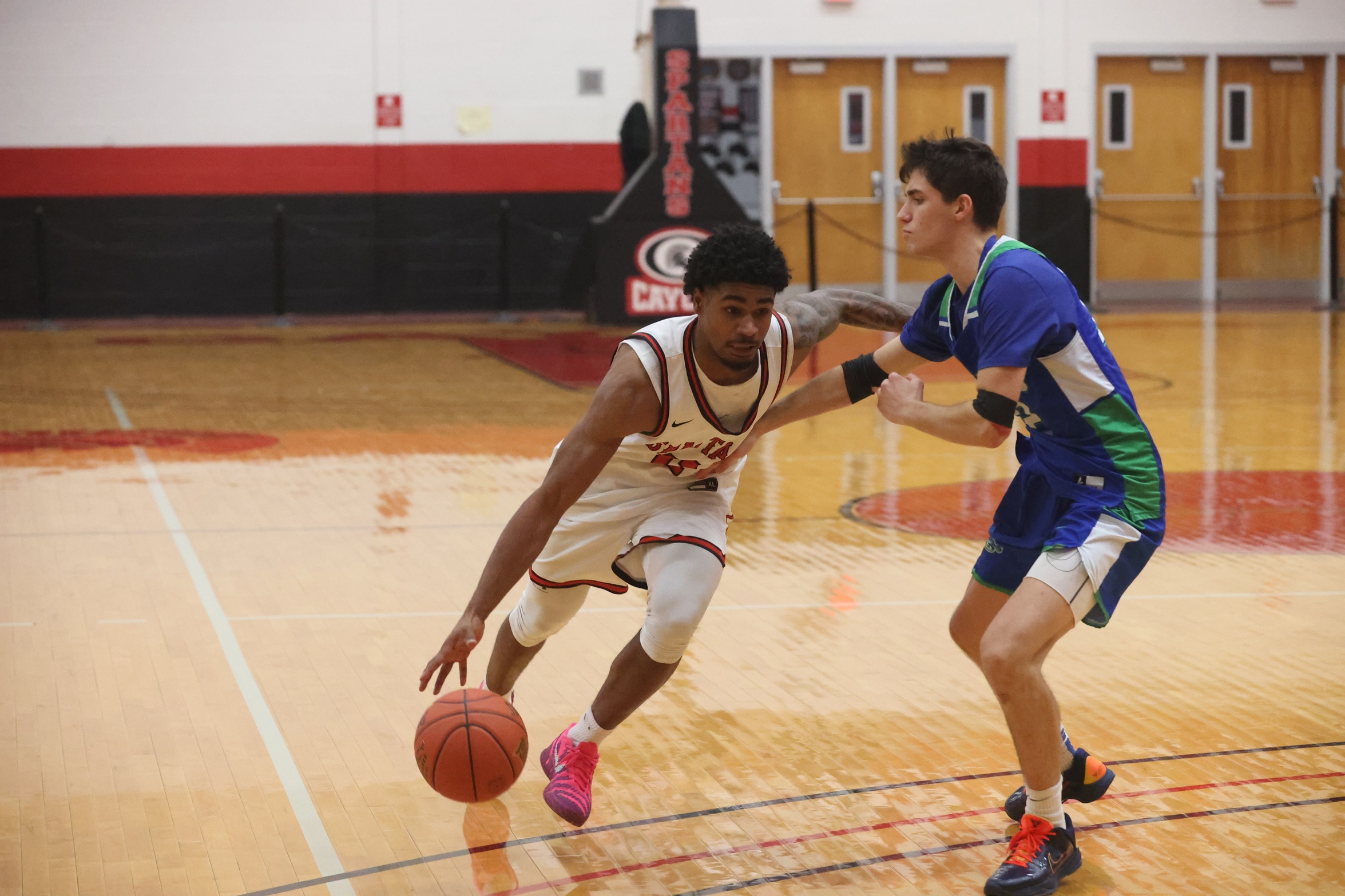 A Cayuga player drives against a Finger Lakes Community College defender.