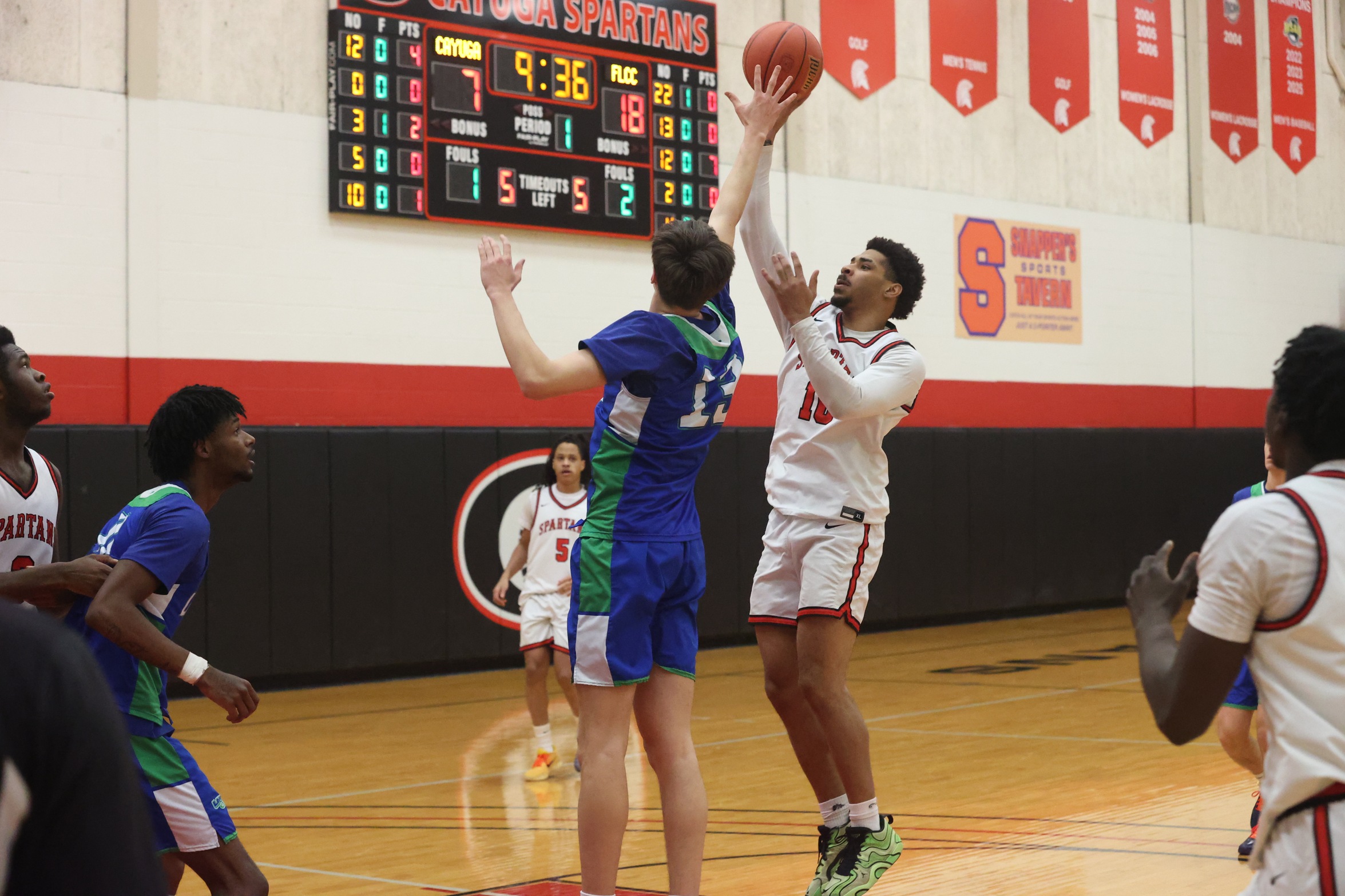 A Cayuga player shoots over a Finger Lakes Community College defender.