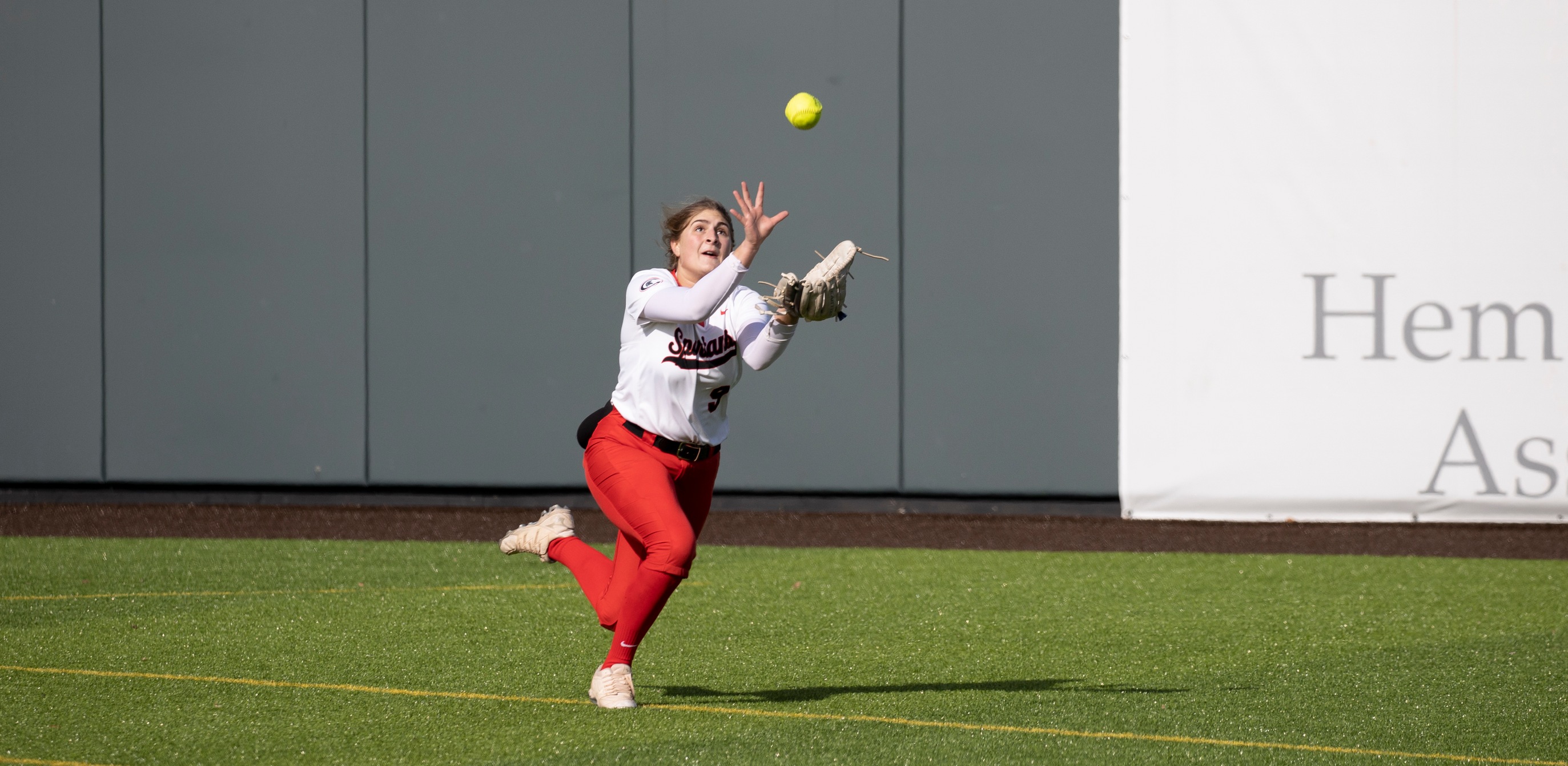 Centerfielder Lexie Cottrill makes a diving catch in the second game against Niagara CCC on Saturday. The Spartans lost both games by scores of 20-12 and 17-9.